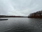 The view of the lake from one of the docks. The lake curves around to the right in the distance, disappearing behind gray and brown trees.