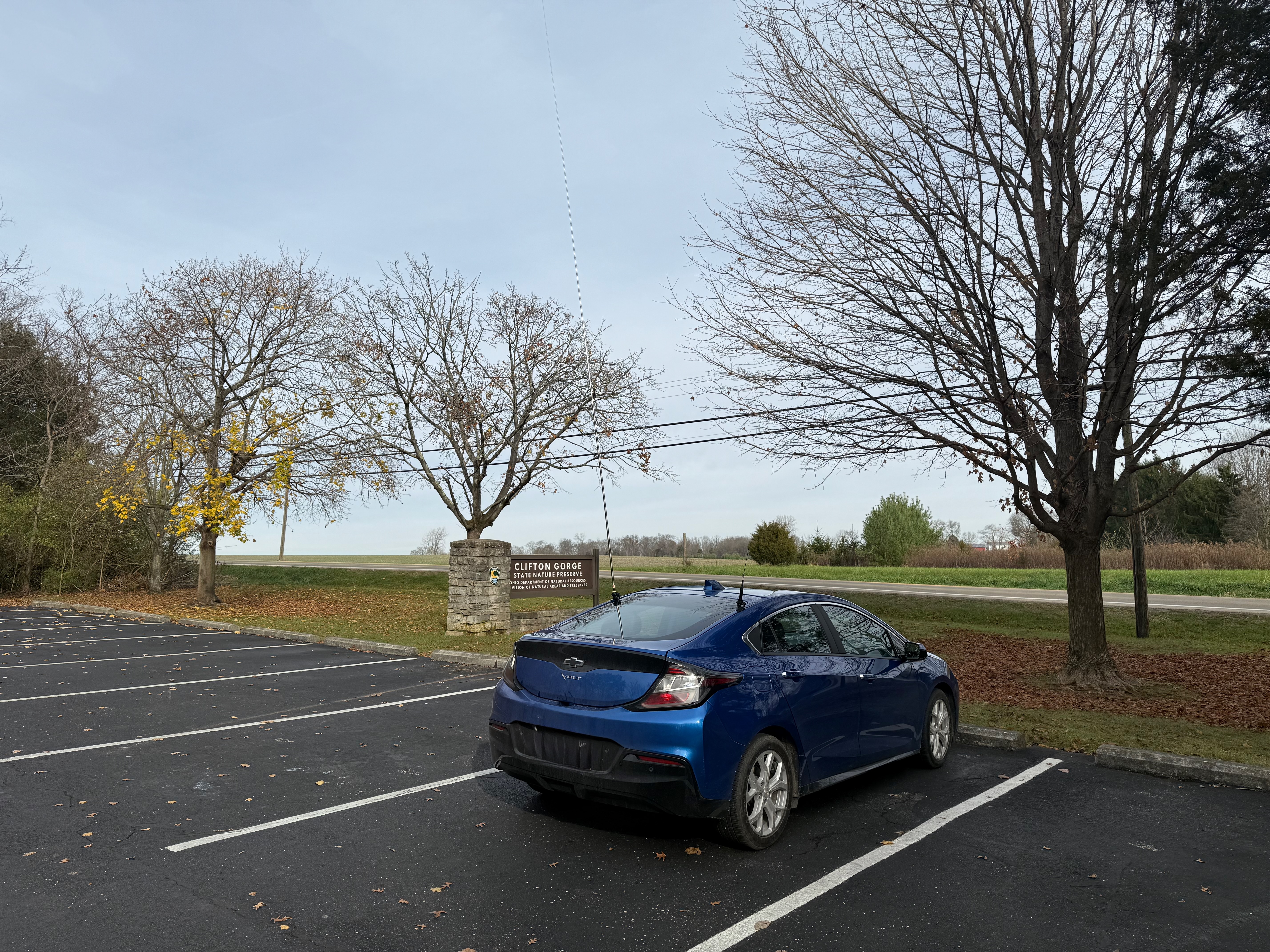 My car parked at Clifton Gorge. In the background is the park sign that reads 'Clifton Gorge State Nature Preserve'.